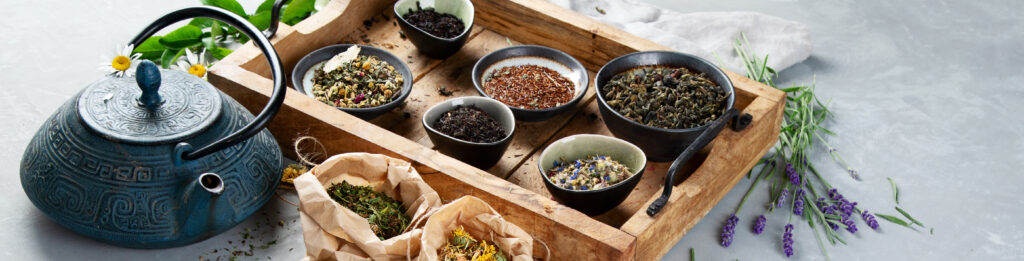 Various kinds of herbal teas with a teapot on a table