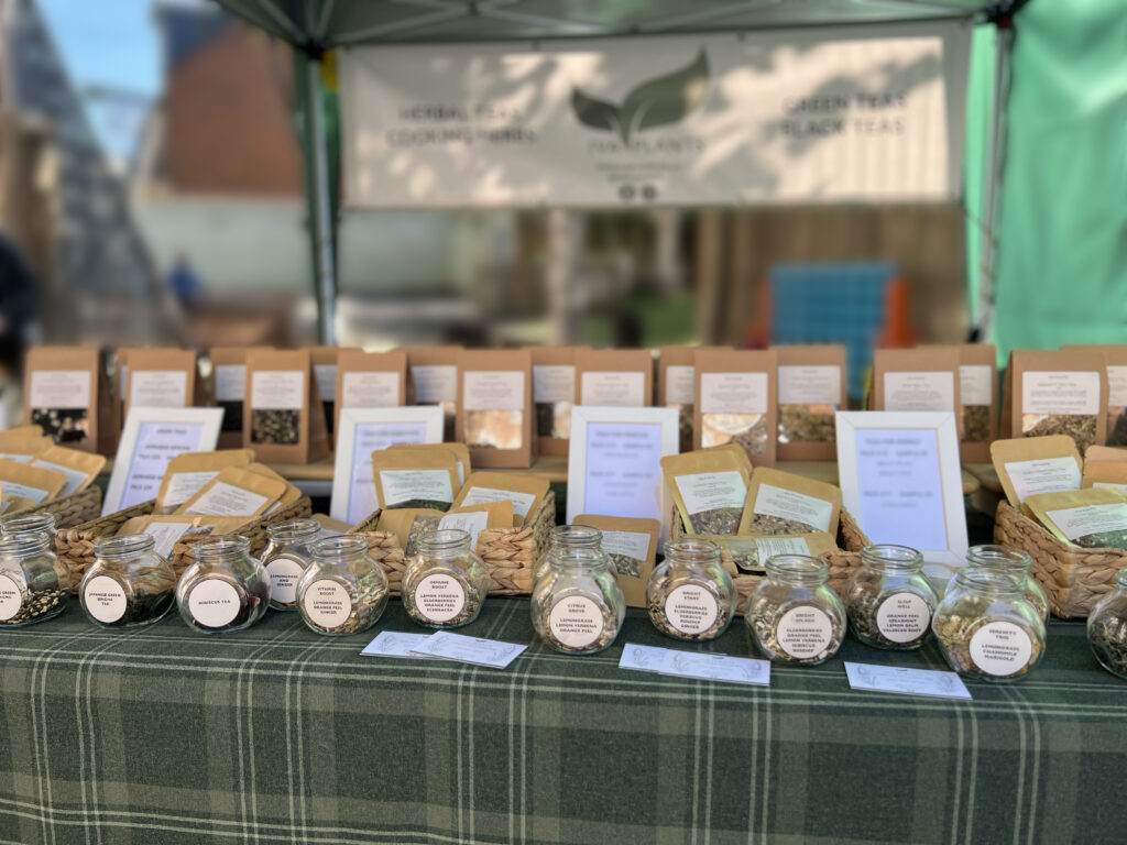 IVA Plants stall at Brook Green Market with a gazebo, displaying herbal, Japanese green, and black Ceylon teas